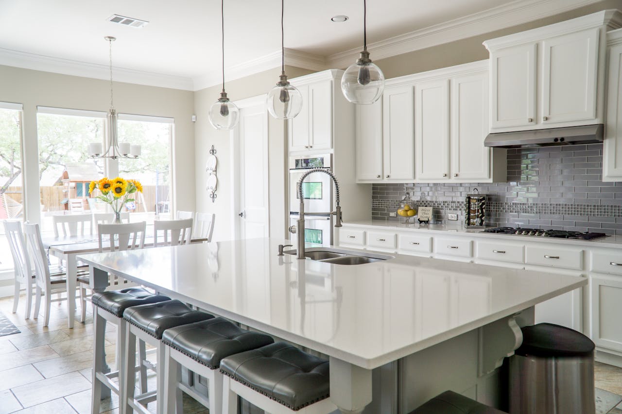 Mastering the First Impression: Your intriguing post title goes here Spacious modern kitchen with white cabinets and island in natural light.